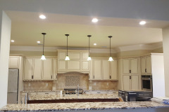Kitchen with ceiling lights in the wall cutout as well as pendant lights