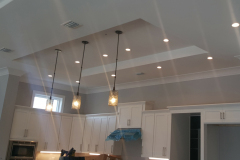 Kitchen with tray ceiling, 4-inch LED cans, pendant lighting over the island and under-cabinet lighting