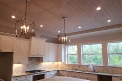 LED cans and pendant lights in a tongue and groove wood ceiling